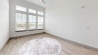 Located at 3951 34th St S in Saint Petersburg, FL, this thoughtfully designed 2-bedroom, 2-bathroom residence offers a clean, contemporary aesthetic across a single-floor layout. The open-concept living area seamlessly connects the kitchen, dining, and living spaces, all finished with light wood-style flooring that enhances the bright, airy ambiance. The kitchen is a standout feature, boasting white shaker cabinetry, a herringbone-pattern tile backsplash, granite countertops, a center island with pendant lighting, and a full suite of stainless steel appliances. The living room is bathed in natural light from a dramatic bank of oversized windows with transom panes and elevated ceilings, creating an expansive, open feel. Both bedrooms are carpeted for comfort and include ceiling fans and natural light from well-positioned windows. The generously sized primary bedroom offers a notably open feel. Both bathrooms mirror the home's modern design with granite-topped vanities, gold-toned hardware, marble-style tiled tub and shower surrounds, and clean white tile flooring. Additional conveniences include three closets and an in-unit laundry room, rounding out this well-appointed Saint Petersburg residence.