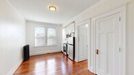 Located at 66 Adelaide St in Detroit's vibrant Midtown neighborhood, this efficient one-bedroom, one-bathroom unit offers a well-designed layout across a single floor. Rich, polished hardwood floors flow seamlessly throughout every room, adding warmth and character to the bright, neutral interior.

The combined living, dining, and kitchen area forms the heart of the unit. Large double-pane windows with blinds allow ample natural light to fill the open space. The kitchen is efficiently integrated into the main living area, featuring white cabinetry, stainless steel appliances including a refrigerator, range, and microwave, complemented by a clean white finish that maintains a cohesive aesthetic.

The bedroom is a comfortable, well-proportioned retreat, featuring crown molding, natural light from a window, and notable storage — two dedicated closets provide generous organization options rarely found in compact units.

The bathroom is accessible from the main living area. Classic white panel doors with brass hardware are found throughout, contributing to a timeless, clean design sensibility. Crown molding and wide baseboards add architectural detail that elevates the overall finish of the space.

This unit combines practical layout efficiency with classic Detroit residential character, making it a functional and charming urban living option.