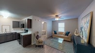 This single-floor residence offers a thoughtfully designed layout that balances comfort and functionality across its key living spaces. The open-concept living area is anchored by durable wood-look flooring, neutral-toned walls, and a ceiling fan with integrated lighting, creating a bright and welcoming atmosphere. A window with blinds allows natural light to filter into the room, enhancing its airy feel.

The kitchen is a standout feature, showcasing rich dark-stained wood cabinetry with ample upper and lower storage, marble-style countertops, a stainless steel sink, and black appliances including a range and microwave. The layout maximizes counter space and provides an efficient work triangle for everyday cooking.

Both bedrooms are generously proportioned, each equipped with ceiling fans, wood-look flooring, and windows that bring in natural light. The rooms offer a calm, restful ambiance with neutral wall tones and closet access.

The bathroom is clean and functional, featuring a full-size soaking tub with an overhead shower, white surround walls, and wood-look tile flooring. The space is finished with simple, crisp fixtures that contribute to its tidy, low-maintenance design.

Overall, this residence presents a cohesive, modern aesthetic with practical finishes suited for comfortable everyday living.