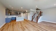 Located at 3813 Broadway Ave in Grand Prairie, TX, this contemporary three-story home offers 3 bedrooms, 4 bathrooms, and a well-designed layout spread across three distinct floors. The main level greets you with an open-concept living and kitchen area finished with warm luxury vinyl plank flooring. The kitchen is a standout, featuring grey shaker-style cabinetry, a white subway tile backsplash, light quartz countertops, stainless steel appliances, pendant lighting, and a large center island with a built-in sink — ideal for both cooking and entertaining. The living area is bright and open, with recessed lighting and a staircase featuring rich wood newel posts and sleek metal balusters. The second floor hosts the primary bedrooms and additional bathrooms. Bedrooms are carpeted and filled with natural light from large windows, with ceiling fans providing comfort. The bathrooms are finished with large-format marble-look tile, grey vanity cabinetry, quartz countertops, and glass-enclosed showers or soaking tub combinations. A dedicated laundry room with upper cabinetry and hardwood-style flooring adds everyday convenience. The third floor offers additional flexible living space. Neutral grey walls and consistent finishes unify the home's modern, clean aesthetic throughout.