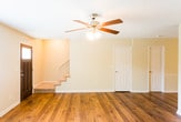 Located at 7301 Brainerd Rd in Chattanooga, TN, this two-story home combines classic charm with practical design throughout its well-appointed layout. Rich hardwood flooring flows through the main living areas, anchoring the warm, inviting atmosphere of each room.

The living room is a standout space, centered around a classic brick fireplace that serves as a natural focal point. A ceiling fan with light fixture adds comfort, while large windows with blinds allow ample natural light to fill the room.

A second living or entry area features its own ceiling fan, a staircase leading to the upper floor, and a dark front door with a glass accent panel, creating a welcoming first impression upon entry.

The kitchen is well-equipped with dark cabinetry, granite-style countertops, and a crisp white subway tile backsplash. Stainless steel appliances — including a refrigerator, dishwasher, electric range, and over-the-range microwave — provide a cohesive, modern look. A dedicated walk-in pantry with built-in shelving offers generous storage space. The kitchen also benefits from natural light through a large window with plantation shutters.

Textured ceilings are found throughout the home, adding a subtle design element that complements the overall aesthetic of this Chattanooga residence.