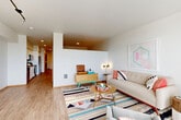 Located at 4455 35th Ave SW in Seattle's West Seattle neighborhood, this thoughtfully designed one-bedroom, one-bathroom residence offers a bright and efficient floor plan across a single level. Light wood-style flooring flows throughout, tying together a cohesive modern aesthetic.

The open-concept living and dining area is bathed in natural light from large floor-to-ceiling windows that lead out to a private balcony with views of surrounding greenery. The kitchen is well-appointed with crisp white shaker cabinetry, dark countertops, stainless steel appliances including a dishwasher, range, microwave, and refrigerator, as well as a textured tile backsplash and a deep undermount sink.

A versatile den provides a flexible space ideal for a home office or secondary lounge. The hallway connects the main living areas to the bedroom and bathroom, offering generous closet storage with four dedicated closets throughout the unit. The bathroom features white cabinetry, a wide vanity with a single sink, dark countertops, and a large mirror. The bedroom provides a comfortable and quiet retreat. The entrance welcomes residents with clean, well-lit finishes that set the tone for the rest of this polished, contemporary home.