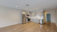 Located at 24 Gould Street in Reading, MA, this well-appointed 2-bedroom, 2-bathroom unit offers a thoughtfully designed single-floor layout with a clean, contemporary aesthetic throughout. The open-concept kitchen and living area serves as the heart of the home, featuring light hardwood-style flooring, recessed lighting, and a stylish kitchen equipped with sleek gray cabinetry, white quartz countertops, a subway tile backsplash, and a full suite of stainless steel appliances including a refrigerator, range, microwave, and dishwasher. A charming barn-style sliding door adds a distinctive accent to the living space. The spacious primary bedroom is carpeted for comfort and benefits from natural light through a large window, with access to a dedicated closet. The second bedroom also features hardwood-style flooring and a bright window with outdoor views. Both bathrooms are finished in a clean, neutral palette with modern vanities and fixtures. A well-lit hallway with recessed lighting and four total closets throughout the unit provide ample storage. The overall ambiance is modern, fresh, and move-in ready, offering a comfortable living environment in a convenient Reading, MA location.