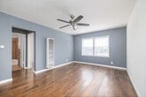 Located on Crenshaw Boulevard in Los Angeles, this well-appointed 1-bedroom, 1-bathroom unit offers a thoughtfully designed single-floor layout. Warm hardwood flooring runs throughout the main living and bedroom areas, lending a cohesive and inviting feel to the space. The living area is bright and airy, featuring soft blue-gray walls, white trim, and a ceiling fan with integrated lighting. A wall-mounted heating unit and a window with horizontal blinds complete this comfortable room.

The galley-style kitchen is efficiently designed with dark espresso cabinetry, light granite countertops, a mosaic tile backsplash, and tile flooring. Stainless steel appliances—including a gas range, microwave, and full-size refrigerator—provide modern functionality, while a double-basin sink adds everyday convenience.

The bedroom offers a comfortable footprint with the same warm hardwood flooring, a ceiling fan, natural light from a window, and a built-in mirrored closet with overhead cabinetry for ample storage. A separate closet and hallway provide additional organizational space throughout the unit.

The bathroom features a tub and shower combination surrounded by large-format stone-look tile, paired with a white vanity and clean, neutral finishes. The overall design is practical, clean, and well-maintained throughout.
