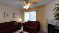 Located at 600 Scotia Ln in Fayetteville, North Carolina, this single-floor home offers a comfortable and functional layout designed for everyday living. The living room serves as the centerpiece of the space, featuring warm, neutral-toned walls and a textured ceiling fitted with a classic multi-blade ceiling fan with integrated lighting — providing both comfort and illumination. Large vertical blinds frame a sliding glass door that fills the room with natural light and provides direct access to an outdoor area, offering a seamless connection between interior and exterior living. The living room is well-proportioned, providing ample space for seating arrangements and relaxed gatherings. Tile flooring runs through the space, adding to the clean and practical feel of the home. A framed wall accent adds a decorative touch, contributing to the inviting ambiance of the room. The overall character of this home is defined by its bright, airy atmosphere and straightforward, livable design — making it a practical and welcoming residence in the Fayetteville area.