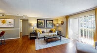 This single-floor, two-bedroom, one-bathroom residence offers a well-designed layout that balances comfort and functionality throughout. The living room serves as the heart of the home, featuring rich hardwood flooring, warm neutral walls, crown molding, and a large sliding glass door that floods the space with natural light while providing direct access to an outdoor patio. The adjacent dining area continues the hardwood flooring and is defined by wainscoting detail, crown molding, and ample wall space for décor.

The galley-style kitchen is outfitted with warm wood cabinetry, dark granite-style countertops, a tile backsplash, and stainless steel appliances including a refrigerator, dishwasher, and range, all set over easy-to-maintain tile flooring.

Both bedrooms offer plush carpeting and generous closet space. The primary bedroom includes a ceiling fan, natural light from a large window, and a spacious vanity area just outside the bathroom, featuring a wide granite-topped counter, large mirror, and bright vanity lighting. The full bathroom is well-appointed with wood cabinetry, a granite-style countertop, a shower-tub combination, and tile flooring, completing this comfortable and thoughtfully laid-out home.