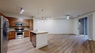 This contemporary apartment, located in The Enclave, offers a harmonious blend of comfort and style across its 1020 square feet. The open-concept design seamlessly integrates the kitchen, living, and dining areas, creating a spacious feel enhanced by ample natural light from large windows.

The kitchen is a highlight, featuring warm wood cabinetry, stainless steel appliances, and elegant granite countertops. A central island provides additional workspace and casual dining options. Modern track lighting and pendant fixtures add both functionality and aesthetic appeal.

The apartment boasts three bedrooms, including a generous 150 square foot primary bedroom. All bedrooms feature wood-look flooring and large windows, offering both comfort and brightness. Two full bathrooms showcase clean lines with neutral-toned tile flooring, white fixtures, and granite vanity tops.

Throughout the space, the wood-look flooring adds warmth and continuity. The hallway, with its crisp white walls and doors, connects the living spaces efficiently. A standout feature is the balcony accessible through sliding glass doors, perfect for enjoying outdoor views.

Attention to detail is evident in the ceiling fans, window treatments, and subtle crown molding. This thoughtfully designed apartment combines modern amenities with a welcoming ambiance, creating an ideal living space for comfort and style.