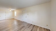 Located at 3306 James Dale Rd in Columbia, MO, this single-floor unit offers three bedrooms and one full bathroom within a practical, well-organized layout. The living room serves as a welcoming common area, finished with light-toned luxury vinyl plank flooring and featuring sliding glass patio doors that allow abundant natural light and views of the surrounding greenery. The entry area continues the same LVP flooring, creating a cohesive and easy-to-maintain surface through the main living spaces. The three bedrooms are carpeted in a neutral tone, providing a comfortable feel underfoot. The primary bedroom is a well-proportioned room featuring two separate doors — one leading to a closet and another to the hallway — along with ceiling ventilation for climate control. The secondary bedrooms are bright and functional, each with windows that bring in natural light and outdoor views. The bathroom is finished with white square tile surrounding a full tub-shower combination, complemented by neutral walls for a clean, utilitarian aesthetic. Throughout the unit, textured ceilings, white panel doors with brass hardware, and warm beige walls maintain a consistent and straightforward design. A connecting hallway ties all rooms together efficiently, completing this compact yet thoughtfully arranged home.