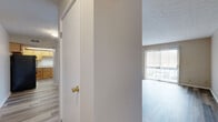 Located at 6592 Steinway Dr in Reynoldsburg, Ohio, this one-bedroom, one-bathroom residence offers a well-organized single-floor layout that makes efficient use of its space. The living room serves as the central gathering area, highlighted by durable luxury vinyl plank flooring in a cool grey-toned wood finish and a full sliding glass door fitted with vertical blinds that opens to an outdoor view of surrounding greenery, filling the room with natural light. The layout flows seamlessly from the living room toward the kitchen, which features warm-toned natural wood cabinetry, a stainless steel sink, laminate countertops, and a dishwasher — providing functional prep and storage space. The bedroom is a comfortable, well-proportioned room with its own window fitted with horizontal blinds, continuing the consistent LVP flooring found throughout the unit. A dedicated closet offers practical storage. The full bathroom includes a single-sink vanity with wood cabinetry, a full-size soaking tub and shower combination, and wood-look flooring that ties into the overall aesthetic. Textured ceilings are present throughout, and neutral wall tones create a clean, move-in-ready ambiance across the entire home.