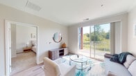 Located at 1620 80th St E in Inver Grove Heights, Minnesota, this single-floor residence offers a thoughtfully designed layout with modern finishes throughout. The open living area is anchored by large sliding glass doors that lead to a private balcony, framing views of lush greenery and providing an abundance of natural light. Light-toned walls and wood-style flooring complement the bright, airy atmosphere of the living space.

The kitchen is a standout feature, showcasing white shaker cabinetry with crown molding, quartz countertops, a subway tile backsplash, and a generous island with seating. Stainless steel appliances, including a refrigerator, range, microwave, and dishwasher, are paired with pendant and track lighting to create a functional and stylish cooking environment.

The bedrooms are carpeted and well-lit by oversized windows that invite natural light and outdoor views. Each room offers a calm, neutral palette conducive to rest and relaxation. The bathrooms feature white cabinetry with brushed nickel hardware, white countertops, tile flooring, and tub-shower combinations, maintaining a clean and consistent design aesthetic throughout the residence.