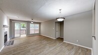 Located at 7889 Roswell Rd in Sandy Springs, GA, this single-floor residence offers a well-organized layout with a cohesive, neutral color palette throughout. The living room serves as the heart of the home, showcasing wood-look flooring, a classic fireplace with a tiled surround and white mantel, and a ceiling fan overhead. A sliding glass door opens directly to a private outdoor balcony, allowing natural light to flow in and providing views of the surrounding greenery. Adjacent to the living area, the dining space features a pendant light fixture and continues the same durable flooring, with an open sightline into the kitchen. The kitchen is thoughtfully appointed with white shaker-style cabinetry, granite-look countertops, a stainless steel gas range, and an over-the-range microwave, offering both style and functionality. The bedrooms are carpeted for comfort, each equipped with ceiling fans and ample natural light from well-positioned windows. Closet access is conveniently located within the bedrooms. The bathrooms are clean and functional, featuring white tiled tub-shower combinations with chrome fixtures. Textured ceilings are consistent throughout the home, adding a classic finishing detail to the overall design.