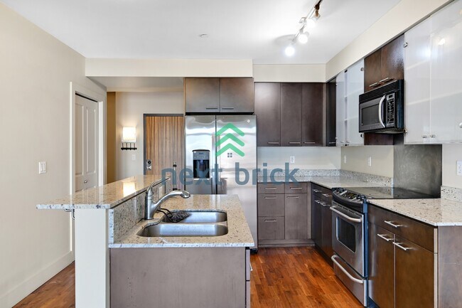 Building Photo - Top-Floor 1-Bedroom + Den with Space Needle Views & Exceptional Building Amenities