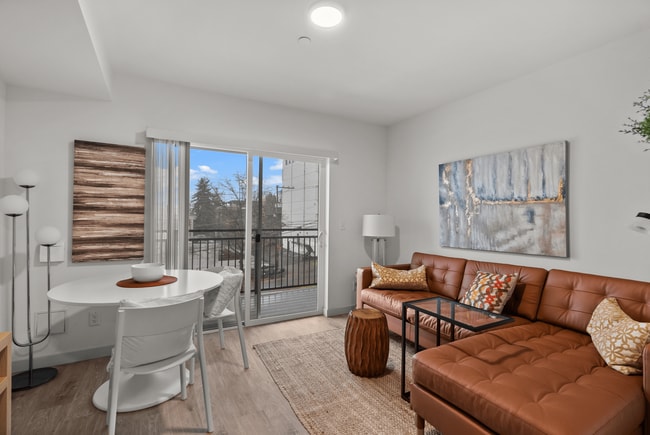 Bright living and dining area with access to a private balcony. - The Ruby