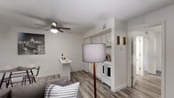 This thoughtfully laid-out 1-bedroom, 1-bathroom unit offers a practical and modern living experience across a single floor. The open-concept living area features durable wood-look flooring throughout, crisp white walls, and a ceiling fan with integrated lighting, creating a bright and airy atmosphere. A compact, efficiently designed kitchen sits adjacent to the living space, equipped with white cabinetry, a white range, and a refrigerator — maximizing every inch of available space. A small bar-height table provides a convenient dining area just steps from the kitchen.

The living room is comfortable and versatile, with a window that allows natural light to fill the space, complemented by modern hexagonal wall shelving and tasteful décor accents.

The bedroom is a well-proportioned retreat, highlighted by a ceiling fan, hardwood-style flooring, and pendant lighting that adds a stylish, contemporary touch. A sliding glass door with vertical blinds opens to an outdoor area, filling the room with natural light and providing direct exterior access.

The bathroom is clean and functional, featuring a full tub-shower combination. Throughout the unit, the consistent flooring, neutral color palette, and modern fixtures create a cohesive and inviting living environment.