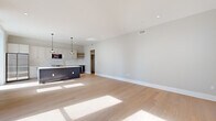 Located on Philadelphia's prestigious Broad Street, this thoughtfully designed 2-bedroom, 5-bathroom residence showcases a seamless blend of modern aesthetics and refined craftsmanship. Wide-plank light hardwood flooring flows throughout, complemented by a neutral palette that enhances the sense of openness and light.

The open-concept kitchen and living area serves as the heart of the home, anchored by a striking two-tone island featuring a dark slate base and white quartz countertop with gold-finish fixtures. White shaker cabinetry, a subway tile backsplash, floating wood shelving, a built-in beverage refrigerator, and stainless steel appliances round out this chef-caliber kitchen, illuminated by stylish pendant lighting.

The hallways are defined by elegant crown molding and bold dark-paneled interior doors with matte black hardware, creating a sophisticated contrast against the light walls and floors. The generously sized primary bedroom features tall windows overlooking the city streetscape, filling the room with natural light.

The bathrooms are appointed with marble-look tile flooring in a classic dot pattern, warm wood vanities with stone countertops, matte black fixtures, and frameless glass-enclosed showers with marble tile surrounds. A custom walk-in closet with built-in shelving, hanging rods, and drawer units provides ample, organized storage. This residence offers a refined urban living experience in the heart of Center City.