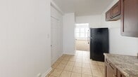 This 600 square foot apartment in Chicago offers a practical and efficient living space. The single-floor layout comprises three bedrooms, including a generous primary bedroom of 190 square feet, a kitchen, a hallway, and one bathroom. The apartment features a neutral color palette with white walls throughout, creating a bright and airy atmosphere. Large windows in several rooms allow for ample natural light, enhancing the sense of space. The floors are covered with plush beige carpeting in the bedrooms and living areas, while the kitchen and bathroom feature durable tile flooring. The kitchen is equipped with dark wood cabinetry, providing ample storage, and includes modern appliances. The bathroom is well-appointed with tiled walls and a combination tub-shower unit. Ceiling-mounted light fixtures and radiators in various rooms ensure comfort throughout the seasons. The apartment's compact yet functional design makes efficient use of the available space, ideal for those seeking a cozy urban dwelling in the heart of Chicago.