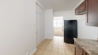 This 600 square foot apartment in Chicago offers a practical and efficient living space. The single-floor layout comprises three bedrooms, including a generous primary bedroom of 190 square feet, a kitchen, a hallway, and one bathroom. The apartment features a neutral color palette with white walls throughout, creating a bright and airy atmosphere. Large windows in several rooms allow for ample natural light, enhancing the sense of space. The floors are covered with plush beige carpeting in the bedrooms and living areas, while the kitchen and bathroom feature durable tile flooring. The kitchen is equipped with dark wood cabinetry, providing ample storage, and includes modern appliances. The bathroom is well-appointed with tiled walls and a combination tub-shower unit. Ceiling-mounted light fixtures and radiators in various rooms ensure comfort throughout the seasons. The apartment's compact yet functional design makes efficient use of the available space, ideal for those seeking a cozy urban dwelling in the heart of Chicago.