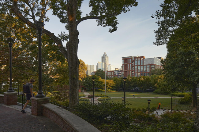 Experimente la tranquilidad de la vida urbana con esta vista de un parque sereno frente a un horizonte moderno. - Inspire