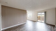 Located at 4277 Larson St in Olivehurst, CA, this single-floor, 2-bedroom, 1-bathroom residence offers a well-organized layout designed for comfortable everyday living. The living and dining areas feature gray wood-look laminate flooring and a textured ceiling, with a ceiling fan adding functionality. Natural light fills the space through multiple windows, and a sliding glass door opens directly onto a private patio with a wooden railing — a practical outdoor extension of the living area. The kitchen is designed with efficiency in mind, featuring a peninsula layout with a built-in electric cooktop, complementary countertops, a sink, dishwasher, and refrigerator. Both bedrooms are finished with soft wall-to-wall carpeting and include sliding-door closets for convenient storage. Warm taupe accent walls appear throughout, creating a cohesive, neutral color palette. The bathroom is outfitted with a full tub-shower combo, clean white fixtures, and wood-look flooring. A dedicated hallway connects the rooms, and the unit benefits from five closets in total, offering generous storage throughout. The layout is practical and well-suited for individuals or small households seeking a manageable, move-in-ready home.