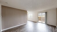 Located at 4277 Larson St in Olivehurst, CA, this single-floor, 2-bedroom, 1-bathroom residence offers a well-organized layout designed for comfortable everyday living. The living and dining areas feature gray wood-look laminate flooring and a textured ceiling, with a ceiling fan adding functionality. Natural light fills the space through multiple windows, and a sliding glass door opens directly onto a private patio with a wooden railing — a practical outdoor extension of the living area. The kitchen is designed with efficiency in mind, featuring a peninsula layout with a built-in electric cooktop, complementary countertops, a sink, dishwasher, and refrigerator. Both bedrooms are finished with soft wall-to-wall carpeting and include sliding-door closets for convenient storage. Warm taupe accent walls appear throughout, creating a cohesive, neutral color palette. The bathroom is outfitted with a full tub-shower combo, clean white fixtures, and wood-look flooring. A dedicated hallway connects the rooms, and the unit benefits from five closets in total, offering generous storage throughout. The layout is practical and well-suited for individuals or small households seeking a manageable, move-in-ready home.
