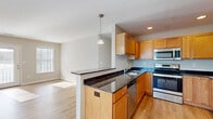 Located at 1 Abby Lane in Ballston Lake, NY, this two-floor, 4-bedroom, 2-bathroom home offers a well-designed layout with practical living spaces throughout. The open-concept kitchen and living room serve as the heart of the home, featuring warm honey-toned cabinetry, dark granite countertops, a peninsula with pendant lighting, stainless steel appliances including a range, microwave, dishwasher, and refrigerator, as well as a tiled backsplash and light hardwood-style flooring that extends into the living area. Natural light flows in through windows fitted with vertical blinds, creating a bright and welcoming atmosphere. The four bedrooms are carpeted and well-proportioned, with the primary bedroom offering generous space and multiple windows. The bathrooms include a clean, functional walk-in shower with light wood-style flooring and a vanity with ample storage. A hallway connects the bedrooms, and two closets provide additional storage throughout. The attached garage features an automatic opener and offers convenient interior access. Neutral-toned walls and consistent finishes throughout the home lend a cohesive and move-in-ready aesthetic suited for everyday living.