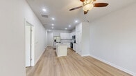 Located at 1151 Hunter Trl in Acworth, Georgia, this single-story 2-bedroom, 2-bathroom home offers a clean, modern design with light hardwood-style flooring running throughout. The open-concept kitchen and living area forms the heart of the home, featuring white shaker cabinetry, granite countertops, a central island with an undermount sink, and a full suite of stainless steel appliances including a French door refrigerator, range, and microwave. Recessed lighting illuminates the space, complemented by a ceiling fan overhead. A pantry and hallway provide added storage and flow.

Both bedrooms are bright and well-proportioned, each with ceiling fans, large windows fitted with blinds that bring in ample natural light and views of the surrounding greenery. The primary bedroom offers a comfortable retreat with its own dedicated closet. The two bathrooms are finished with granite-top vanities and chrome fixtures; one includes a full tub-shower combo with classic white subway tile surround. A dedicated laundry room houses a full-size washer and dryer with wire shelving above. The attached garage and additional closets round out the practical storage offerings of this well-appointed home.