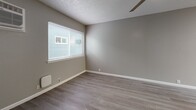 This 1-bedroom, 1-bathroom unit in Davis, CA offers a thoughtfully designed layout that maximizes every square foot. Throughout the space, light gray walls, white trim, and durable wood-style laminate flooring create a clean, cohesive aesthetic complemented by textured ceilings.

The combined kitchen and living area serves as the heart of the unit. The kitchen is well-equipped with white shaker-style cabinetry, marble-look quartz countertops, a mosaic tile backsplash, and a full suite of stainless steel appliances, including a refrigerator, electric range, and microwave. A window above the sink brings in natural light.

The bedroom is a comfortable, well-proportioned room featuring a ceiling fan, a wall-mounted air conditioning unit, a baseboard heater, and a window for natural light. Mirrored sliding-door closets provide generous storage while visually expanding the space. A secondary closet offers additional storage off the hallway.

The bathroom is finished with a marble-look vanity countertop, white cabinetry, tile-surround shower/tub, and light tile flooring, maintaining the modern and clean design found throughout the unit.

A central hallway connects the main living areas, with the mirrored closet doors adding depth and brightness to the passage.
