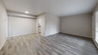Located at 2420 E Abram St in Arlington, TX, this single-story home offers three bedrooms and two bathrooms within a compact, efficiently arranged floor plan. The living area features wood-look plank flooring in a cool gray tone, neutral walls, and an open sightline into the kitchen, creating a connected and functional common space. The kitchen is outfitted with white cabinetry, granite-style countertops, and black appliances including a refrigerator and dishwasher, complemented by tile-style flooring that ties the space together cleanly. Each of the three bedrooms is finished with wall-to-wall carpet and equipped with a ceiling fan, providing comfort throughout. The bedrooms are well-proportioned, with the primary bedroom offering a generous layout. One bedroom features a sliding-door closet and a window that brings in natural light. The bathrooms include a vanity with a granite-style countertop and a tiled tub-shower combination with wood-look flooring. Throughout the home, a consistent neutral color palette and clean finishes contribute to a move-in-ready feel. The layout is practical and straightforward, making efficient use of the available space across a single level.