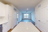 Located on Loblolly Place in La Plata, Maryland, this well-appointed 2-bedroom, 2-bathroom single-floor home offers a clean, modern aesthetic with thoughtful design throughout. The open-concept layout seamlessly connects the kitchen, dining, and living areas, creating a bright and functional shared space. The kitchen is a standout feature, showcasing crisp white cabinetry, a central island with a quartz countertop, stainless steel appliances including a French door refrigerator, built-in microwave, range, and dishwasher, all complemented by recessed lighting overhead. Wood-look flooring flows consistently throughout the home, adding warmth and continuity. The living area is anchored by a ceiling fan and large windows that invite natural light and offer open outdoor views. Both bedrooms are well-sized, featuring large windows with exterior views, ceiling fans, and neutral wall tones that create a calm, restful atmosphere. The primary bedroom includes a generously sized walk-in closet with wire shelving systems. The bathrooms are finished with white cabinetry, sleek hardware, and wide vanity mirrors. Three closets in total provide ample storage across the home. The overall ambiance is fresh, contemporary, and move-in ready.