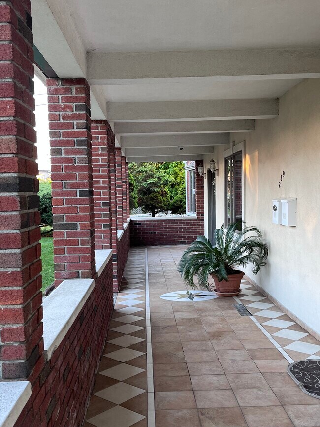 Entrada con porche cubierto y puerta izquierda con acceso a nivel de calle. - 239 Kingston Ave