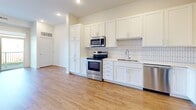 Located at 251 Eldorado Dr in Jordan, MN, this one-bedroom, one-bathroom unit offers a well-designed layout with modern finishes across a single floor. The open-concept kitchen and living area serves as the heart of the home, featuring crisp white shaker cabinets, a geometric tile backsplash, stainless steel appliances including a range, microwave, dishwasher, and refrigerator, and light wood-tone flooring that flows throughout the space. Recessed lighting and abundant natural light enhance the clean, contemporary feel of the kitchen and living room. The bedroom is a comfortable, bright retreat with a large window offering pleasant outdoor views of natural surroundings. It includes access to two closets, providing generous storage for the space. The full bathroom is finished with warm-toned flooring, neutral gray walls, and a tub/shower combination. Additional features include a utility room for added convenience and a private balcony, offering an outdoor extension of the living space. Throughout the unit, light hardwood-style flooring, crisp white trim, and a neutral color palette create a cohesive, modern aesthetic that feels both clean and inviting.