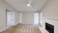 This 2-bedroom, 3-bathroom single-floor home at 7100 Claxton Cir in Raleigh, NC offers a well-organized layout designed for comfortable everyday living. The open living room serves as the heart of the home, featuring vaulted ceilings, a ceiling fan, plush carpeting, a wood-burning fireplace with a classic white surround, and windows that allow natural light to fill the space. An adjacent dining area flows seamlessly into the galley-style kitchen, which is equipped with white shaker cabinets, white quartz countertops, wood-look luxury vinyl flooring, and stainless steel appliances including a refrigerator, electric range, and built-in microwave. The primary bedroom is generously proportioned with vaulted ceilings, a ceiling fan, and a closet. The second bedroom offers its own closet and direct access to a full bathroom featuring a tub-shower combination and updated vanity. A third bathroom includes a standalone walk-in shower with vinyl plank flooring. The home also includes a dedicated laundry area with washer and dryer hookups and overhead shelving, along with a utility room and five closets throughout for ample storage. Neutral tones and clean finishes create a bright, move-in-ready atmosphere throughout.