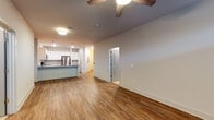 This well-appointed 3-bedroom, 2-bathroom single-floor residence offers a thoughtfully designed open-concept layout that seamlessly connects the living, dining, and kitchen areas. Rich hardwood-style flooring runs throughout the main living spaces, complemented by neutral-toned walls and recessed lighting that create a bright, welcoming atmosphere. Ceiling fans are installed in the main living areas, enhancing comfort year-round.

The kitchen is a standout feature, boasting white shaker-style cabinetry, granite countertops, and a full suite of stainless steel appliances including a refrigerator, range, microwave, and a central island with pendant lighting—ideal for both everyday cooking and entertaining.

The bedrooms offer plush carpeting and ample natural light through blinded windows, providing a cozy retreat. The primary bathroom is elegantly finished with large-format marble-style tile flooring, a sleek glass-enclosed walk-in shower, white cabinetry, and granite countertops. A second full bathroom features a double-sink vanity with granite countertops and white cabinetry, offering generous space and storage.

A welcoming entry hallway leads into the open living area, with convenient access to all bedrooms and bathrooms. The overall design balances modern aesthetics with practical functionality throughout.
