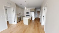 Located at 3130 Monterey Avenue South in Minneapolis, MN, this thoughtfully designed unit offers three bedrooms, two bathrooms, and a functional single-floor layout. The interior is finished with warm, light-toned hardwood-style flooring that flows consistently throughout the main living areas and bedrooms, contributing to a bright and cohesive aesthetic.

The kitchen serves as the heart of the home, featuring a generous central island with a clean white countertop, white cabinetry, a tile backsplash, and a full suite of stainless steel appliances including a gas range, refrigerator, and built-in microwave. Pendant lighting above the island adds a modern, polished touch to the space.

The bedrooms are well-proportioned and filled with natural light from tall windows that offer exterior views. The primary bedroom provides a comfortable retreat, while the two additional bedrooms are versatile enough for guests, a home office, or other needs. Two dedicated closets support ample storage throughout.

The two bathrooms are finished in a clean, contemporary style. One features a walk-in shower with a sliding glass door and a white vanity, while the second includes a full soaking tub with a shower combination and brushed nickel fixtures. Neutral tones and light wood flooring maintain a consistent design language across both bathrooms.
