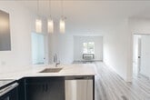 Located at 102 Washington Ave in Belleville, NJ, this thoughtfully designed 2-bedroom, 2-bathroom residence offers a clean, modern aesthetic throughout. Light wood-style flooring flows seamlessly across the single-level layout, complemented by crisp white walls and an abundance of natural light.

The open-concept kitchen serves as a centerpiece of the living space, featuring a striking waterfall-edge quartz island with an undermount stainless steel sink and contemporary pendant lighting overhead. Gray cabinetry pairs with a full suite of stainless steel appliances — including a refrigerator, electric range, microwave, and dishwasher — and a classic subway tile backsplash adds a refined touch. The kitchen opens directly to the living area, creating an inviting, connected atmosphere.

Both bedrooms are well-proportioned and bright, each equipped with individual climate control units and large windows offering views of the surrounding Belleville streetscape. The primary bedroom includes access to a dedicated closet.

The two bathrooms are finished in a modern style. The primary bath features a dual-sink vanity with a white quartz countertop, dark cabinetry, and sleek black-framed mirrors. The second bathroom includes a full soaking tub with a tiled surround and a single-sink vanity. A well-lit hallway connects all rooms efficiently, completing this polished and move-in-ready residence.