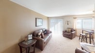 This single-floor residence in Georgetown South offers a well-organized layout designed for comfortable everyday living. The living room serves as the centerpiece of the home, featuring plush wall-to-wall carpeting, warm neutral-toned walls, and a large sliding glass door fitted with vertical blinds that invites an abundance of natural light while providing access to the outdoors. The open feel of this room allows for generous furniture arrangements and flows naturally into a dedicated dining area, complete with its own ceiling light fixture.

The galley-style kitchen is efficiently designed with ample warm-toned wood cabinetry lining both sides, offering considerable storage space. It includes a stainless steel sink, a full-size refrigerator, a dishwasher, and a stovetop, all set atop durable tile flooring.

The bedrooms are carpeted and generously sized, each featuring built-in closets with hanging rods for organized storage. Natural light filters in through windows fitted with blinds. One bedroom features a bold teal accent wall, adding a vibrant focal point to the space, while another includes an eye-catching orange accent wall.

The bathroom is outfitted with a full tub and shower combination, accented by classic white tile surround. Throughout the home, wood-trimmed doorways and neutral walls create a cohesive, understated aesthetic.