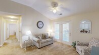 This 2-bedroom, 2-bathroom home in Columbia, South Carolina offers a comfortable and functional single-floor layout. The bright living room is a standout space, featuring vaulted ceilings, a ceiling fan with light, and French doors that open to a private balcony with outdoor views, allowing natural light to fill the room. Soft carpet flooring flows throughout the living areas and bedrooms, contributing to a warm, inviting atmosphere.

The kitchen is well-appointed with warm oak cabinetry extending to the ceiling for generous storage, white appliances including a range and over-the-range microwave, and ample counter space. Adjacent to the kitchen, the dining area comfortably accommodates a dining table and provides a defined space for everyday meals.

Both bedrooms are spacious and carpeted, with the primary bedroom featuring a closet with double doors. The second bedroom includes a window that brings in natural light and neighborhood views. Each bathroom is practical and well-sized; one features hardwood-style flooring, a vanity with light wood cabinetry, a large mirror, and a tub-shower combination. The layout also includes a hallway connecting the key areas of the home, adding to the overall sense of flow and organization throughout this well-designed residence.