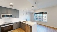 This contemporary 1-bedroom apartment in Denver offers 710 square feet of thoughtfully designed living space. The open-concept layout seamlessly integrates the kitchen, living, and dining areas, creating a spacious feel. The kitchen is a standout feature, boasting sleek gray cabinetry, stainless steel appliances, and a stylish white backsplash. Pendant lighting and a convenient breakfast bar add both functionality and aesthetic appeal.

The living area is bathed in natural light thanks to large windows that offer picturesque city views. Light wood-look flooring runs throughout, complementing the crisp white walls and adding warmth to the space. The bedroom, measuring 140 square feet, provides ample room and features a modern ceiling fan for comfort.

The bathroom showcases a clean, modern design with a floating vanity and large mirror. Additional amenities include recessed lighting, a closet for storage, and climate control vents for year-round comfort. The apartment's neutral color palette and contemporary finishes create a canvas for personal style, making it an ideal home for the discerning urban dweller.