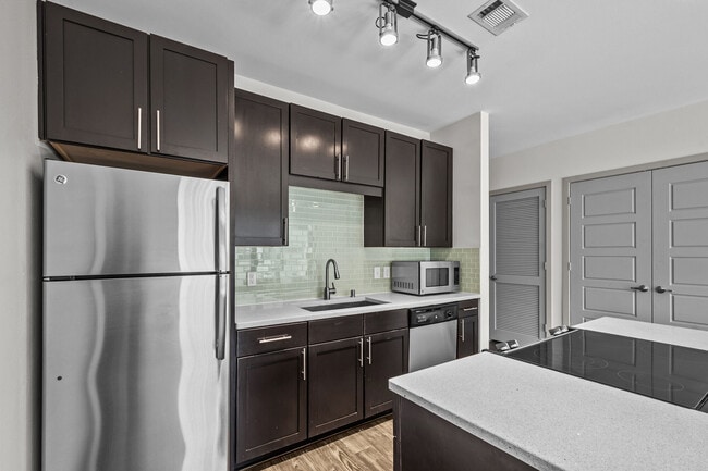 Kitchen with Stainless Steel Appliances - Maple at Med Center Apartments