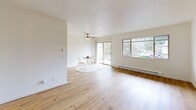 Located at 6170 SW Lombard Ave in Beaverton, Oregon, this one-bedroom, one-bathroom residence offers a well-organized single-floor layout with a bright, clean aesthetic throughout. Warm hardwood-style flooring runs continuously across all living areas, complementing the crisp white walls and textured ceilings that define the home's interior character.

The welcoming entrance leads into a generous living room bathed in natural light from large windows and a sliding glass door that opens onto a private balcony — ideal for enjoying the lush Pacific Northwest surroundings. A ceiling fan and baseboard heating ensure year-round comfort. The combined dining and kitchen area provides a functional space for daily living and entertaining.

The bedroom is a comfortably sized retreat featuring a ceiling fan, a large window with outdoor views, and access to multiple closets — four closets total are distributed throughout the unit, offering exceptional storage. The bathroom is clean and well-appointed, featuring a tub/shower combination with light wood-style flooring and a vanity with ample counter space.

This residence presents a neutral, move-in-ready palette throughout, with thoughtful layout efficiency and abundant natural light making every room feel open and inviting.
