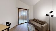 Located at 202 E John St in Champaign, IL, this efficient two-bedroom, one-bathroom unit is thoughtfully laid out across a single floor. The living room serves as the heart of the space, featuring vaulted ceilings that add a sense of openness and hardwood-style flooring that extends through the main areas. A sliding glass door connects the living room directly to a private patio, bringing in natural light and offering convenient outdoor access.

The kitchen is well-appointed with gray shaker-style cabinetry, light marble-look countertops, and a full suite of stainless steel appliances including a range, over-the-range microwave, and refrigerator. The hardwood-style flooring continues here, complementing the clean, modern aesthetic.

Both bedrooms feature neutral carpet and crisp white walls. The primary bedroom accommodates a full-size bed and includes a window with blinds, allowing for natural light while maintaining privacy. The second bedroom is more compact and cozy, with vaulted ceiling angles adding architectural character. Each bedroom benefits from dedicated closet space.

A hallway connects the rooms and provides access to the full bathroom. The unit's bright, neutral palette throughout creates a clean and functional living environment suited for everyday comfort.