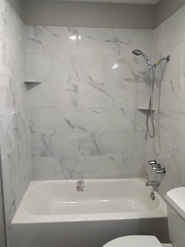 Renovaciones de baño con estilo con revestimientos de azulejos o de superficie sólida. ¡Ven y relájate en tu nuevo hogar! - The Regency