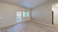 This 2-bedroom, 2-bathroom unit in Lakewood, Washington offers a thoughtfully designed single-level layout. The living room serves as the centerpiece of the home, featuring vaulted ceilings, soft carpeting, and a tile-surround fireplace with a built-in arched niche above the mantle. A glass-paned door opens directly to a balcony, allowing natural light and outdoor views to fill the space.

The kitchen is efficiently arranged with warm wood cabinetry, dark granite countertops, stone tile flooring, and a full suite of stainless steel appliances including a refrigerator, range, and microwave. A peninsula counter provides a functional pass-through to the living area.

Both bedrooms are carpeted and naturally lit by windows with outdoor views. The primary bedroom includes balcony access via a glass door, while the secondary bedroom features a dedicated window and neutral-toned walls. Each bedroom is served by its own full bathroom, both finished with stone tile flooring, wood vanity cabinetry, granite-style countertops, a large mirror, and a tub/shower combination. The layout also includes a hallway and closet for additional storage.
