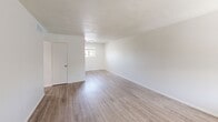 This single-story, one-bedroom, one-bathroom unit in Phoenix, AZ (85018) offers a clean, efficient layout with a bright and neutral aesthetic throughout. Light wood-look flooring runs consistently across all rooms, contributing to a cohesive and easy-to-maintain interior. The open living area welcomes natural light through a window near the entry and features crisp white walls with clean baseboards, creating a simple yet inviting atmosphere. The kitchen is designed for functionality, featuring white cabinetry, gray laminate countertops with ample workspace, a stainless steel sink, and white appliances including a range and refrigerator. A window above the counter brings in natural light and outdoor views. The bedroom offers a comfortable, well-proportioned space with a window that allows natural light in and provides a view of the surrounding greenery. The full bathroom includes a tub/shower combination with tile surround, wood-look flooring, a window for ventilation and natural light, and a vanity with a gray countertop. Throughout the unit, the consistent use of neutral tones, light flooring, and natural light creates a clean and functional living environment well-suited to everyday life in the Phoenix area.