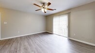 Located at 220 Edgewood Terrace Dr in Jackson, MS, this single-floor residence offers 2 bedrooms and 4 bathrooms within a well-organized layout. The living room is a bright, open space featuring wood-look luxury vinyl plank (LVP) flooring, a ceiling fan with light fixture, and a sliding glass door dressed with vertical blinds that allows generous natural light to fill the room. The kitchen is efficiently designed with gray cabinetry, white countertops, a decorative tile backsplash, black appliances including an electric range and refrigerator, and LVP flooring that carries a clean, cohesive look throughout. The primary bedroom is a spacious retreat with its own ceiling fan, direct access to a closet, and connects to a bathroom featuring a wide marble-veined white countertop vanity with gray cabinetry. The second bedroom offers plush carpeting, a ceiling fan, and a window that brings in natural light. Additional bathrooms include a clean, white tub-shower combination with LVP flooring. Neutral warm-beige wall tones run consistently throughout the home, contributing to a cohesive and calm ambiance. Two closets provide practical storage solutions, and a hallway connects the rooms efficiently across the single floor.