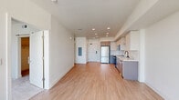 Located on the sixth floor at 251 6th St in downtown Sacramento, this 1-bedroom, 1-bathroom residence offers a thoughtfully designed open-concept layout. Light wood-style flooring flows throughout the main living area, creating a clean, contemporary aesthetic anchored by recessed lighting and crisp white walls.

The kitchen is well-appointed with two-tone cabinetry featuring gray lower cabinets and white upper cabinets, a white subway tile backsplash, stainless steel appliances including a refrigerator, range, microwave, and dishwasher, and a sleek undermount sink. The kitchen opens seamlessly into the combined dining and living area, which is bathed in natural light from a large picture window offering views of the Sacramento skyline. A ceiling fan adds comfort to the space.

The bedroom is carpeted, bright, and generously sized, featuring its own window with city views and a ceiling fan. A dedicated closet provides organized storage. The bathroom is finished with modern gray cabinetry, a white quartz countertop, matte black fixtures, a large frameless sliding glass shower, and built-in open shelving. An in-unit laundry area completes this efficiently designed urban residence.