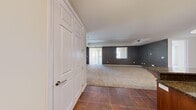 Located at 2405 W Serene Ave in Las Vegas, this Casita Grand end unit offers a well-designed single-floor layout with 2 bedrooms and 2 bathrooms. The open-concept living and kitchen area serves as the heart of the home, where rich wood cabinetry, dark granite countertops, a tile backsplash, and stainless steel appliances — including a refrigerator, stove, and microwave — create a polished, functional kitchen. A central island with pendant lighting adds both workspace and casual dining potential, while recessed lighting illuminates the entire area. Large-format tile flooring transitions seamlessly into plush carpeting throughout the living and bedroom spaces. The expansive living room features arched windows and a sliding glass door that invite abundant natural light. The generously sized primary bedroom includes a tray ceiling with crown molding detail, dual windows, and direct access to a private bathroom equipped with a walk-in shower, wood vanity with granite countertop, and tile flooring. A spacious walk-in closet with built-in shelving and hanging rods provides excellent storage. The second bedroom is equally well-proportioned, with natural light and easy access to the hallway and second bathroom. A dedicated pantry and hallway storage round out this thoughtfully laid-out home.