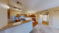 Located at 6885 W Lone Mountain Rd in Las Vegas, NV, this well-appointed 2-bedroom, 2-bathroom residence offers a comfortable and functional single-floor layout. The open-concept kitchen and living area serves as the heart of the home, where rich wood cabinetry, granite countertops, and stainless steel appliances — including a gas range, built-in microwave, and refrigerator — create a stylish and practical cooking space. A breakfast bar peninsula provides additional prep and seating space, while a pendant chandelier adds a warm finishing touch. Hardwood-style flooring flows throughout the kitchen and dining areas, transitioning to plush carpet in the living room and bedrooms. The living room is bright and welcoming, featuring a ceiling fan, multiple windows with blinds, and a private exterior door that brings in natural light. Both bedrooms are generously sized, each equipped with ceiling fans and large windows. The primary bedroom offers a comfortable retreat with its own dedicated bathroom. The two bathrooms are well-finished, featuring granite-topped vanities with rich wood cabinetry, hardwood-style flooring, and a tub-shower combination. A dedicated closet and hallway complete the thoughtful floor plan, making this a well-rounded and move-in-ready residence.