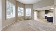 Located in Vancouver, WA, this well-designed two-bedroom, one-bathroom single-floor residence offers a comfortable and functional layout. The galley-style kitchen is a standout feature, showcasing rich dark-stained cabinetry, crisp white quartz countertops, stainless steel appliances including a refrigerator, dishwasher, and microwave, and light hardwood-style flooring. A peninsula provides additional counter space and connects the kitchen to the adjacent living area, which is generously sized with multiple windows that invite natural light and views of the surrounding greenery.

Both bedrooms are finished with soft wall-to-wall carpeting and neutral warm-toned walls. The primary bedroom is notably spacious, featuring a curved corner wall with multiple windows on two sides, filling the room with natural light. The second bedroom also benefits from a window and recessed lighting. Two closets provide ample storage throughout the home.

The bathroom is clean and modern, featuring a large vanity with dark cabinetry, white countertop, an expansive mirror, and light wood-style flooring. The overall aesthetic throughout the home is cohesive and contemporary, with neutral tones, clean lines, and quality finishes that create a bright, move-in-ready living environment.
