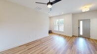Located at 1000 Lassen Dr in Knightdale, NC, this two-story home offers three bedrooms, three bathrooms, and a thoughtfully designed layout spread across two floors. The main level features an open-concept kitchen and living area with warm wood-look flooring, light-toned cabinetry with modern black hardware, and a dedicated laundry space. The clean, neutral palette and abundant natural light create an inviting, airy atmosphere throughout.

Upstairs, the spacious primary bedroom impresses with elevated ceilings, plush carpet, a ceiling fan, and a wide bank of windows that flood the room with natural light. Double panel doors open to a walk-in closet equipped with wire shelving systems for ample storage. Additional bedrooms feature the same wood-look flooring, ceiling fans, and bright windows, offering comfortable and versatile spaces.

The three bathrooms are finished in a crisp, modern style, with one featuring a soaking tub and shower combination with matte black fixtures. A convenient hallway connects the upper-level rooms seamlessly. The home also includes an attached garage with an automatic opener. Throughout, consistent use of soft white walls, panel-style doors in a muted gray-green, and quality flooring selections lend the home a cohesive, contemporary feel.
